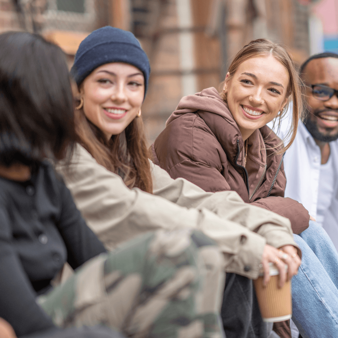 A group of Volunteers - 3 female and one male sitting and enjoying together promoting inclusion